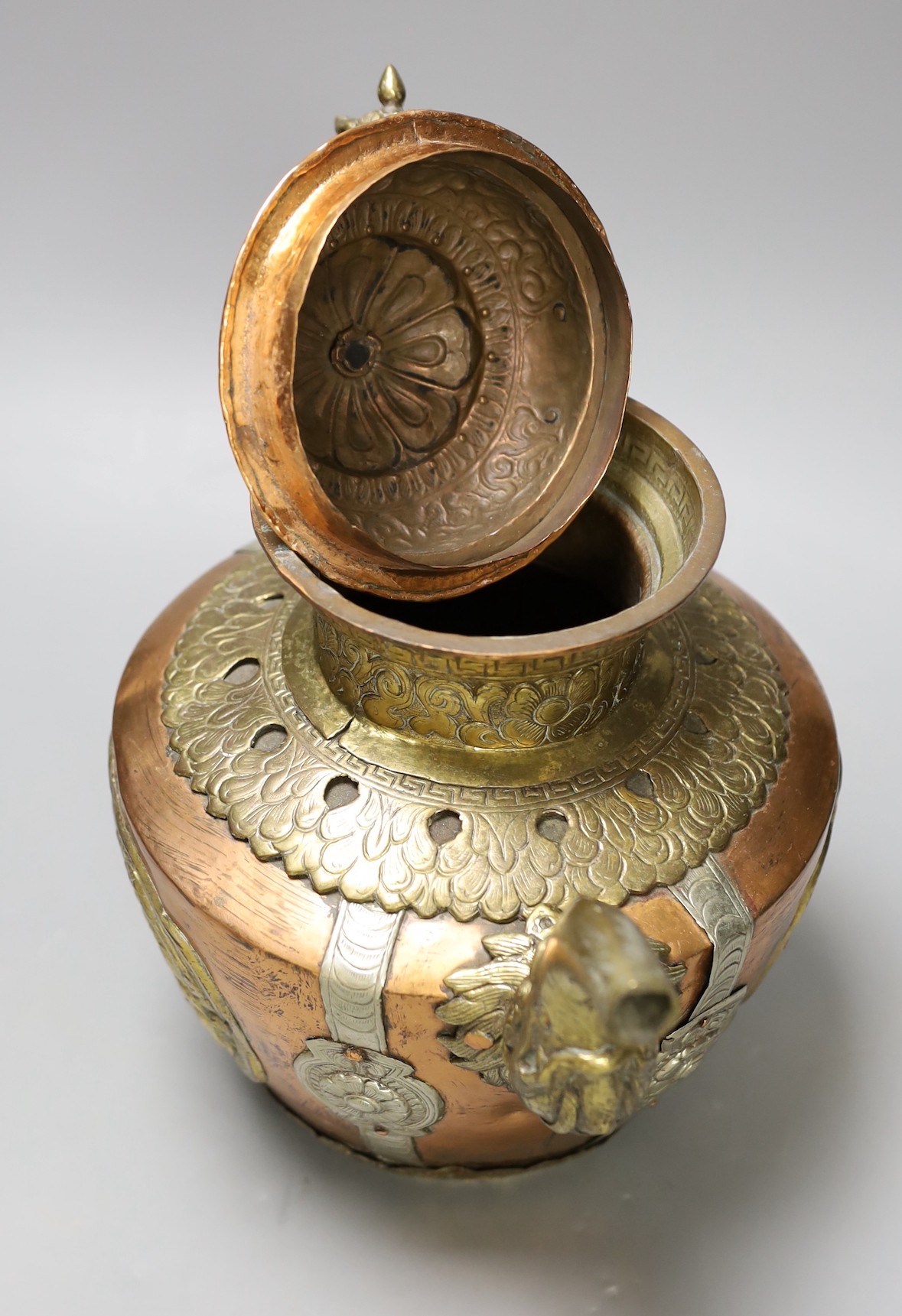 A Tibetan copper and brass ewer with dragon handles, 33cm tall